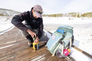 scientist checking data logger to record Yellowstone volcano activity 