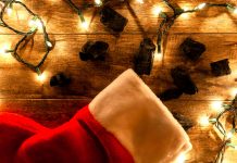 coal pieces next to a christmas stocking with lit twinkle lights