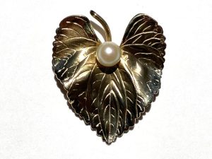 leaf jewelry shaped as a heart with a pearl in the center