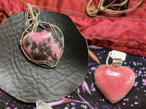 heart shaped stones are used as cabochons for necklaces one is pure pink the other is pink and black